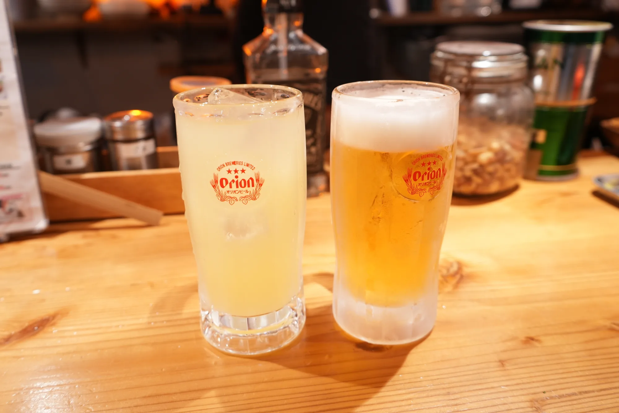 居酒屋のカウンターに置かれたオリオンビールのグラス